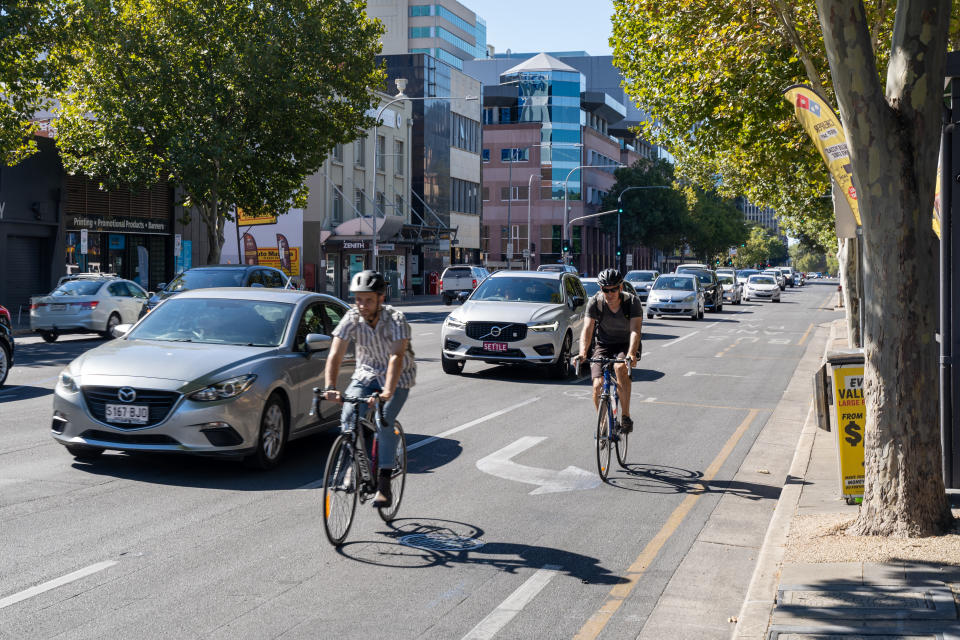 Cyclists passing cars in street. Source: Getty Images