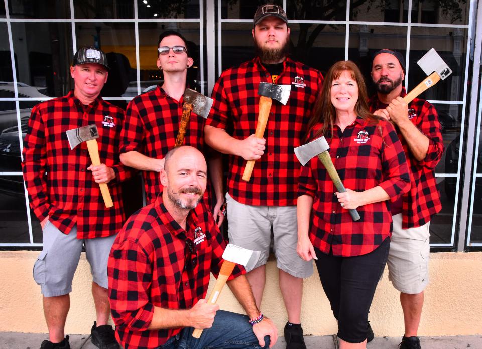The staff and owners of Lumber Jack's Axe House pose for a photo in front of the former Off The Traxx in downtown Melbourne.