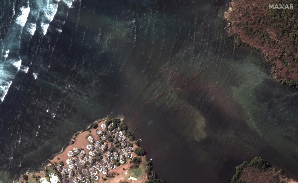This satellite image provided by Maxar Technologies shows booms attempting to contain an oil spill caused by an overturned vessel off the coast of Tobago near Scarborough, Trinidad and Tobago, Wednesday, Feb. 14, 2024. (Maxar Technologies via AP)