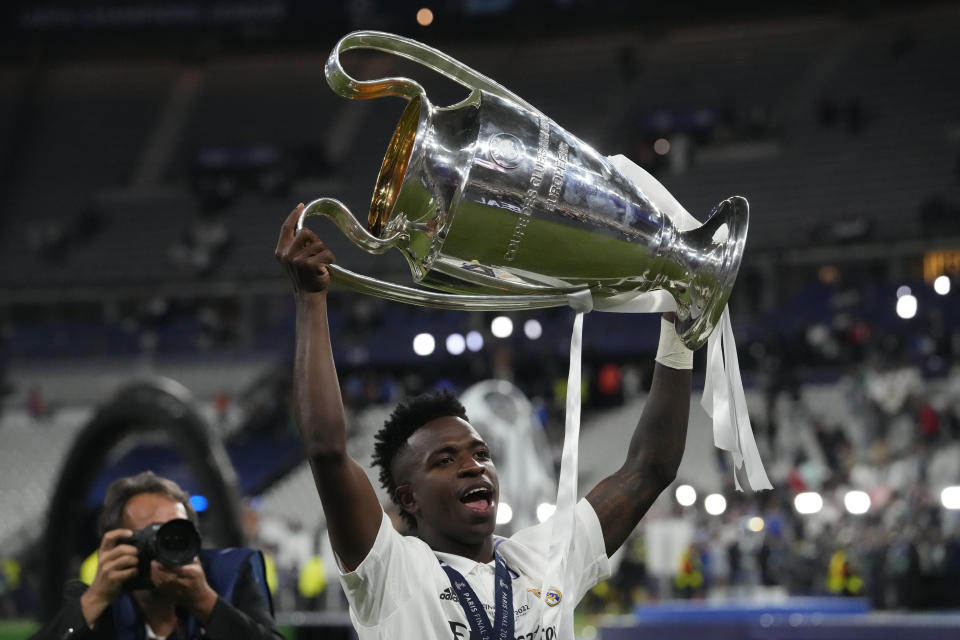 Real Madrid's Vinicius Junior holds the trophy after the Champions League final soccer match between Liverpool and Real Madrid at the Stade de France in Saint Denis near Paris, Saturday, May 28, 2022. (AP Photo/Frank Augstein)