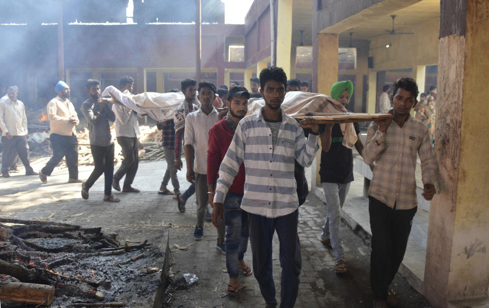 Bodies of victims of Friday's train accident are carried in for cremation in Amritsar, India, Saturday, Oct. 20, 2018. A speeding train ran over a crowd watching fireworks during a religious festival in northern India on Friday evening, killing more than 50 people and injuring dozens more, police said. (AP Photo/Prabhjot Gill)