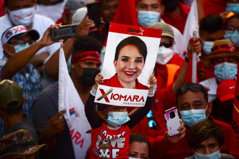 A child holds a sign with a picture of Xiomara Castro during a campaign rally in San Lorenzo, Honduras.