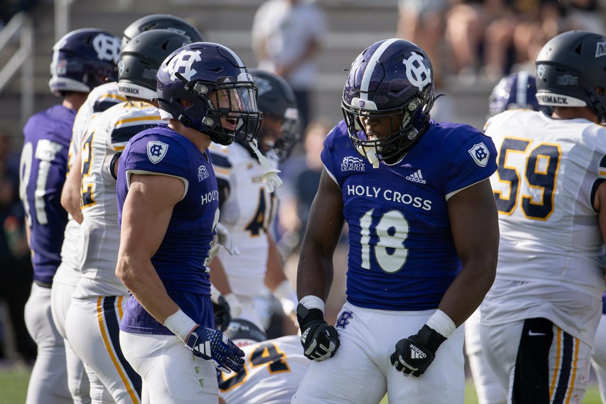 Holy Cross' Terrence Spence, left, and Christian Ross, right celebrate after a big stop versus Merrimack.