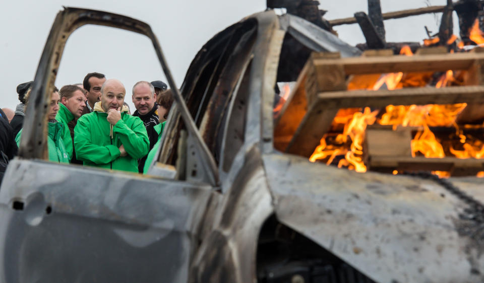 A car burns as workers block the main gate of the Ford plant in Genk, Belgium on Thursday Oct. 25, 2012. Ford Motor Co. announced Wednesday it planned to close a car plant in eastern Belgium — one of its main European factories — by the end of 2014, a move that would result in 4,500 direct job losses and 5,000 more among subcontractors. (AP Photo/Geert Vanden Wijngaert)