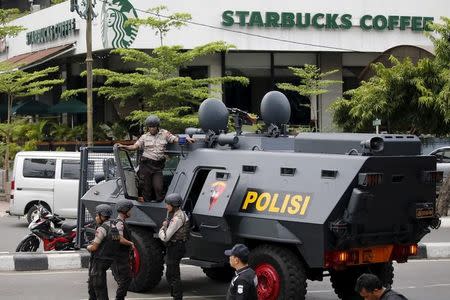 Indonesian policemen with weapons and an armoured vehicle guard in front of a Starbucks cafe at Thamrin business district following a militant attack in Jakarta, January 14, 2016. REUTERS/Beawiharta/Files