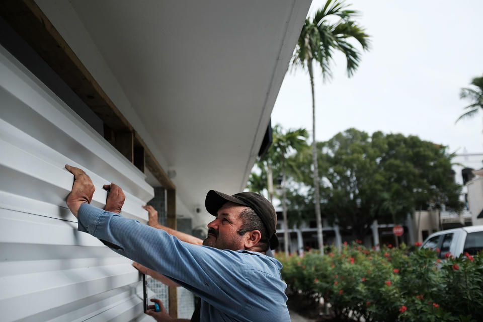 NAPLES, FL - SEPTEMBER 09: Men hold up metal siding as it is placed in front of a business in downtown Naples before the arrival of Hurricane Irma into Southwest Florida on September 9, 2017 in Naples, Florida. The Naples area could begin to feel hurricane-force winds from Irma by 11 a.m. Sunday and experience  wind gusts over 100 mph from Sunday through Monday. (Photo by Spencer Platt/Getty Images)