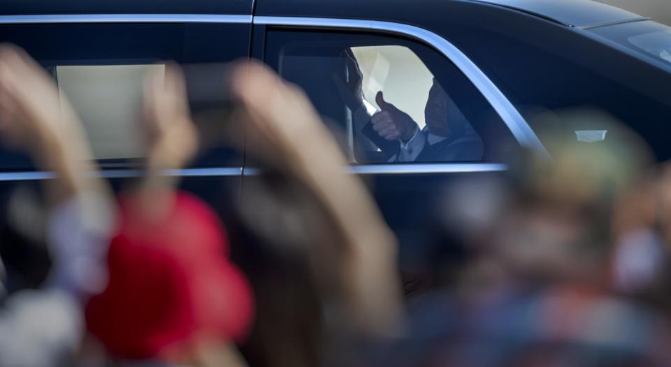 President Trump gives a thumbs-up to supporters from his limo.