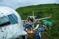 Officials inspect the wreckage of an Air India Express jet at Calicut International Airport in Karipur, Kerala, on August 8, 2020. - Fierce rain and winds lashed a passenger jet carrying 190 people from Dubai that crash landed and tore in two at an airport in southern India killing at least 18 people and injuring scores more, officials said. (Photo by Arunchandra BOSE / AFP) (Photo by ARUNCHANDRA BOSE/AFP via Getty Images)