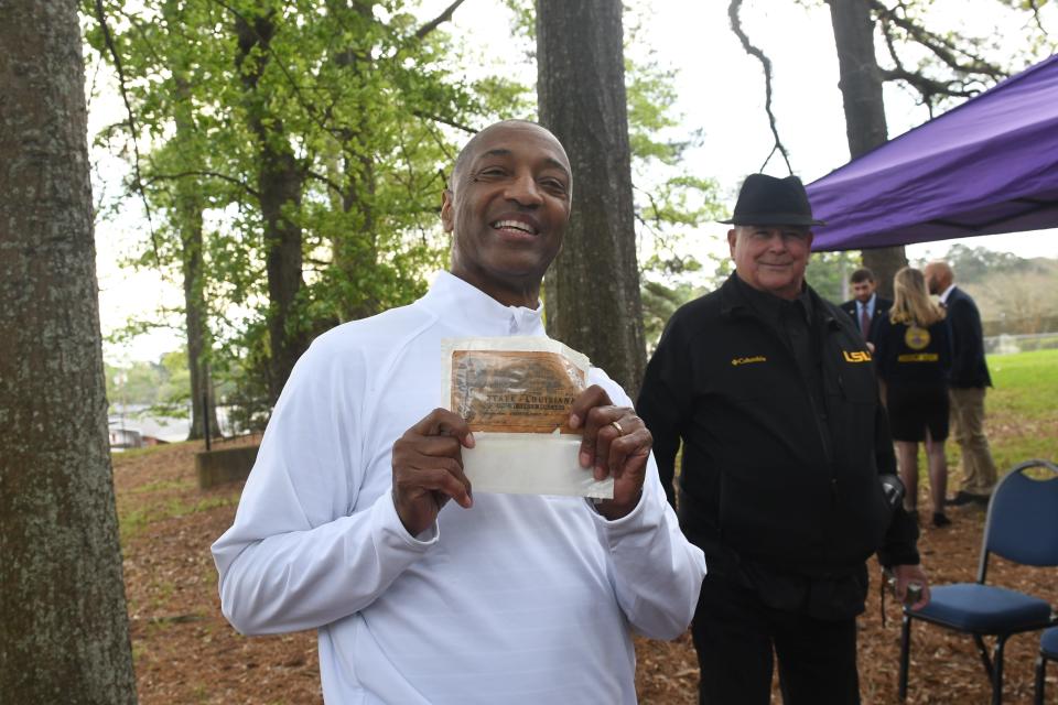 Jackson Sleet (right) of Alexandria gave LSU President William Tate a replica of a Confederate $100 bill that has a picture of the original building that was on the site of where LSU was founded in Pineville. in 1860. Then it was known as Louisiana State Seminary of Learning and Military Academy.