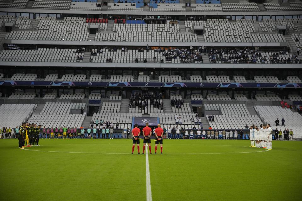 Players observe a minute of silence, in the memory of the fatal victims of a stampede during a soccer match in Indonesia, before the Champions League group D soccer match between Marseille and Sporting at the Velodrome stadium in Marseille, southern France, Tuesday, Oct. 4, 2022. (AP Photo/Daniel Cole)