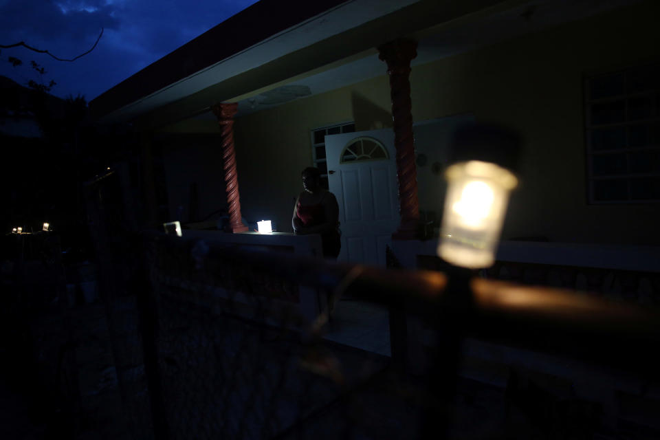 Jannet Rodriguez, 40, stands on the porch of her darkened house in Adjuntas, Puerto Rico, on May 11, 2018. Hurricane Maria left Puerto Rico's fragile power system reeling for months after the storm made landfall in September 2017. (Photo: Alvin Baez/Reuters)