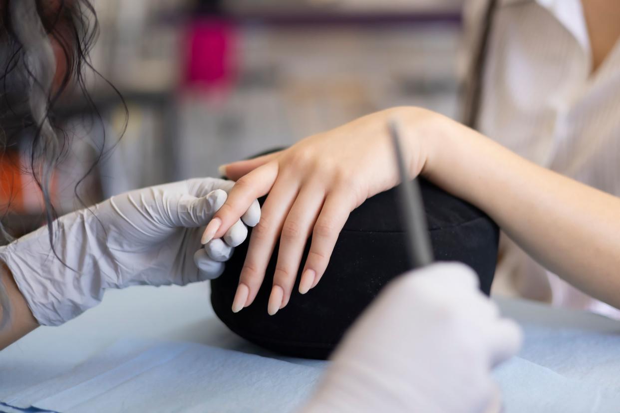 <p>Getty</p> Woman gets acrylic nails done.