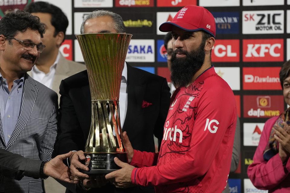 England's skipper Moeen Ali, right, receives trophy after winning the twenty20 series during a presentation ceremony on the end of the seventh twenty20 cricket match between Pakistan and England, in Lahore, Pakistan, Sunday, Oct. 2, 2022. (AP Photo/K.M. Chaudary)