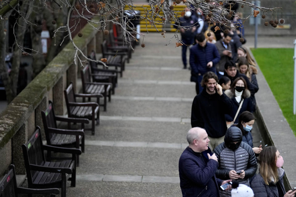 People queue for their vaccination at St Thomas' Hospital in London, Wednesday, Dec. 15, 2021. Long lines have formed for booster shots across England as the U.K. government urged all adults to protect themselves against the omicron variant. (AP Photo/Frank Augstein)