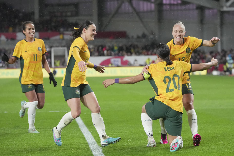 Australia's Sam Kerr, front right, celebrates with her teammates after scoring against England during the women's international friendly soccer match between England and Australia at the Gtech Community Stadium in London, England, Tuesday, April 11, 2023. (AP Photo/Kin Cheung)