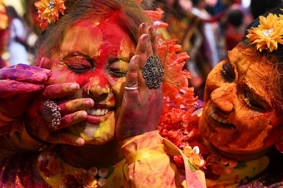 Women in Kolkata covered with gulal, colorful powders associated with the Hindu spring festival of Holi.