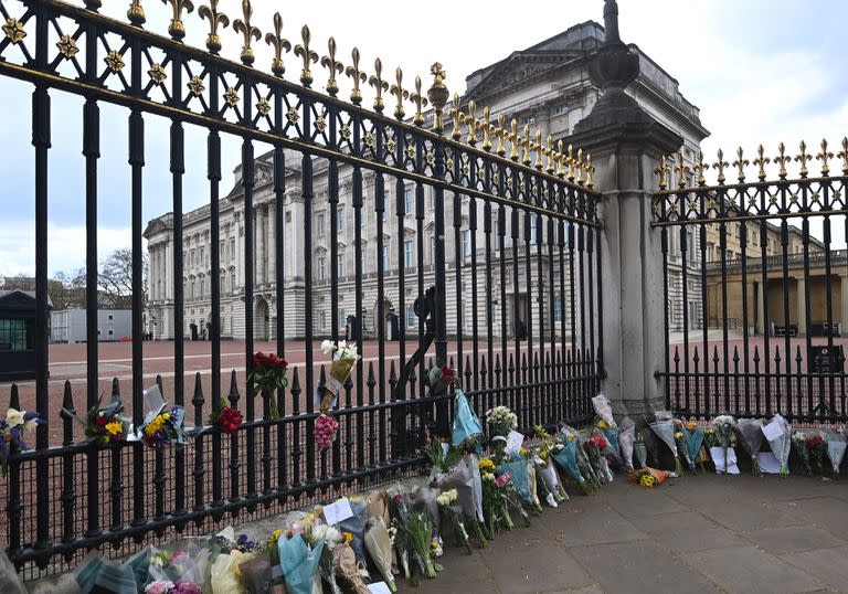 Tras conocerse la noticia de la muerte del príncipe Felipe de Edimburgo, las puertas del Palacio de Buckingham, en Londres, se llenaron de flores que acercaban las personas a modo de tributo. (Foto: Andy Rain/ EFE)