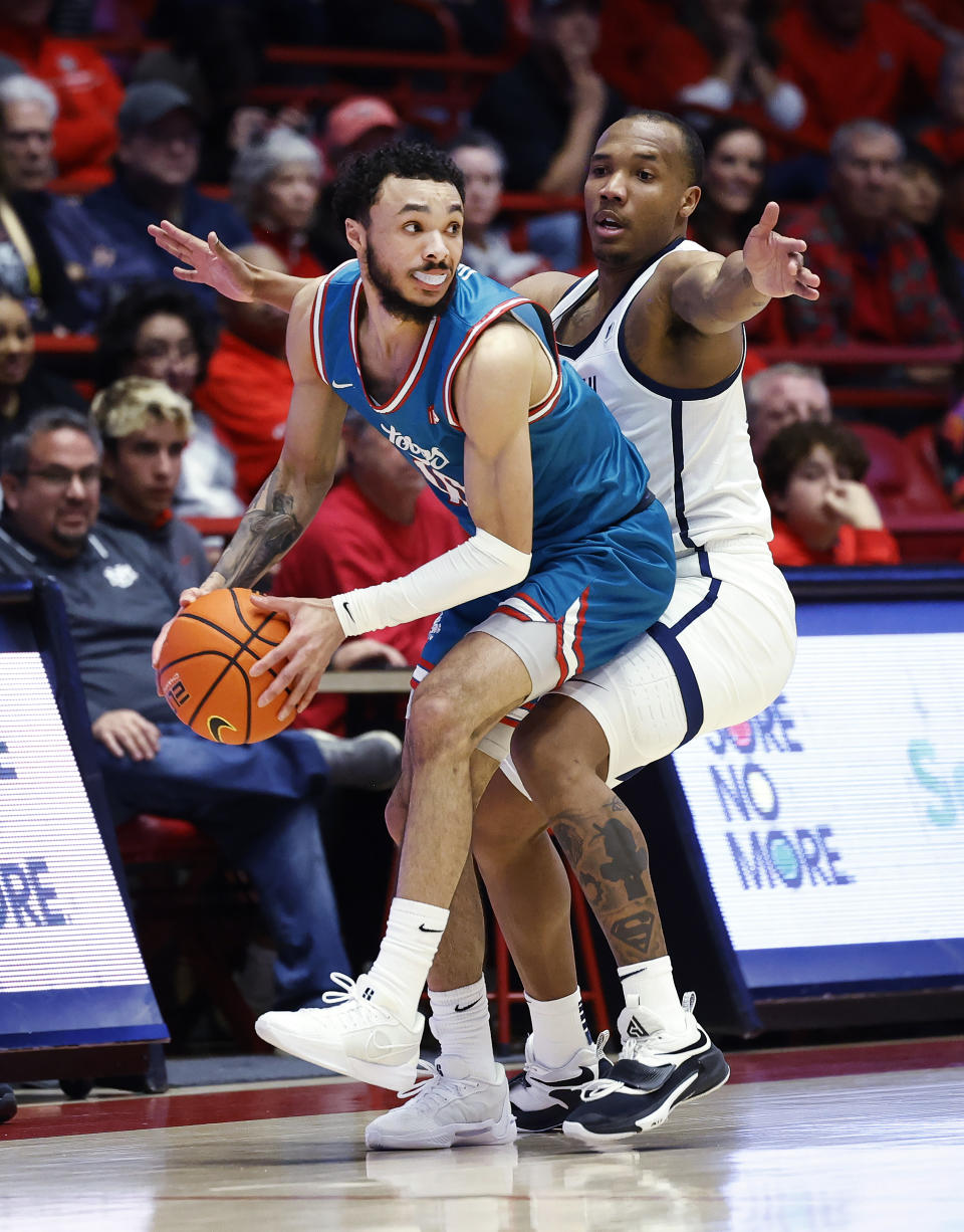 New Mexico guard Jaelen House tries to pass the ball as Utah State guard Darius Brown II defends during the first half of an NCAA college basketball game Tuesday, Jan. 16, 2024, in Albuquerque, N.M. (AP Photo/Eric Draper)