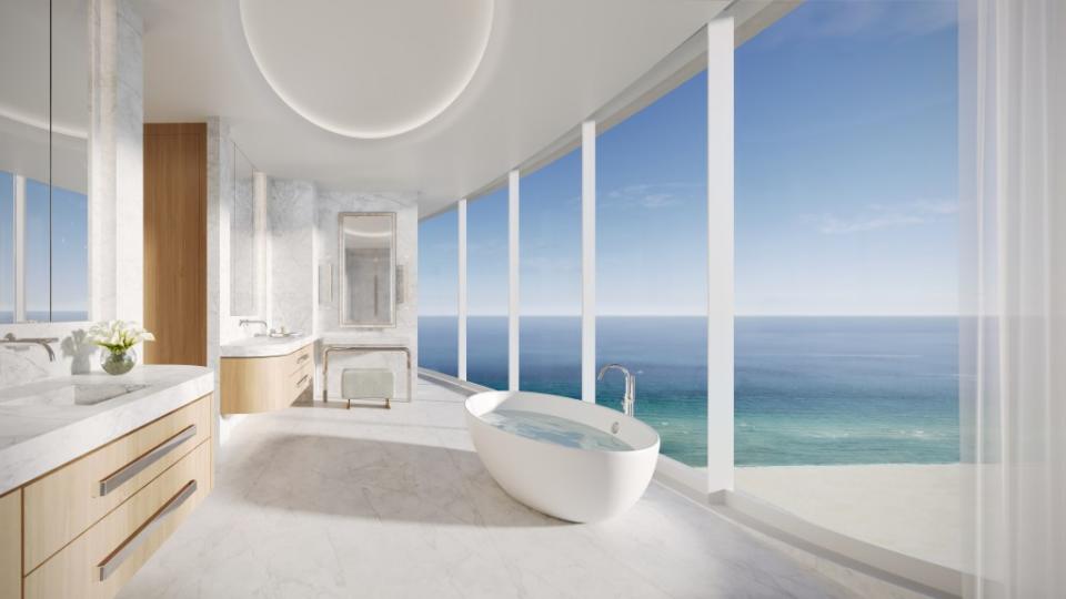 A primary bathroom with a soaking tub and views of the ocean. The Boundary