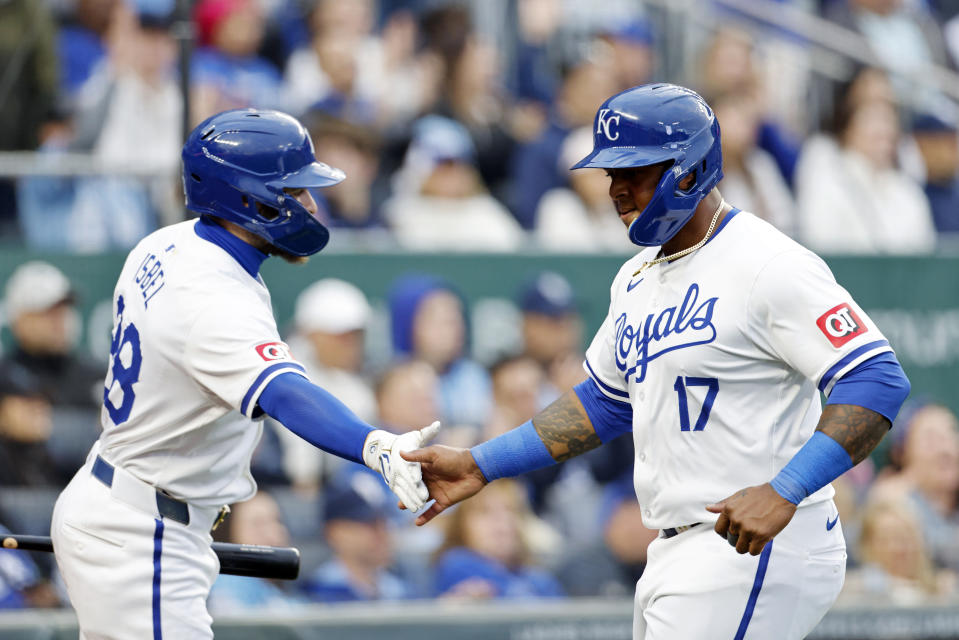 Kansas City Royals' Nelson Velázquez (17) is congratulated at home plate by Kyle Isbel (28) after scoring off a two-run single by Hunter Renfroe (16) during the fifth inning of a baseball game against the Texas Rangers in Kansas City, Mo., Saturday, May 4, 2024. (AP Photo/Colin E. Braley)