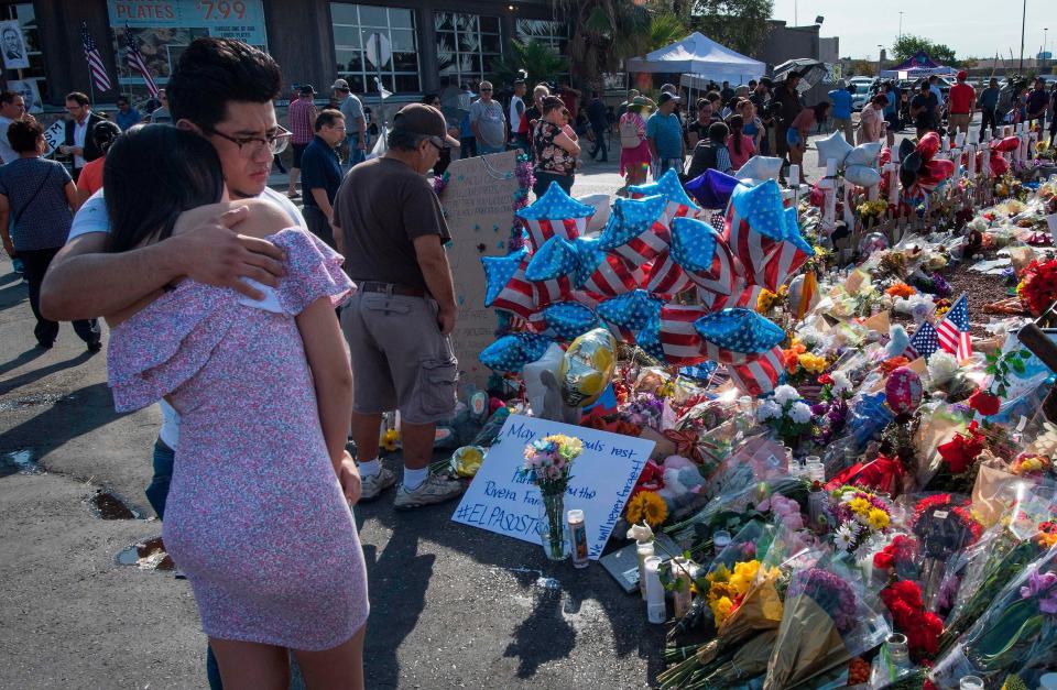 People hug at the makeshift memorial for victims of the shooting that left a total of 22 people dead at the Cielo Vista Mall Walmart, in El Paso, Texas, on Aug. 7, 2019.