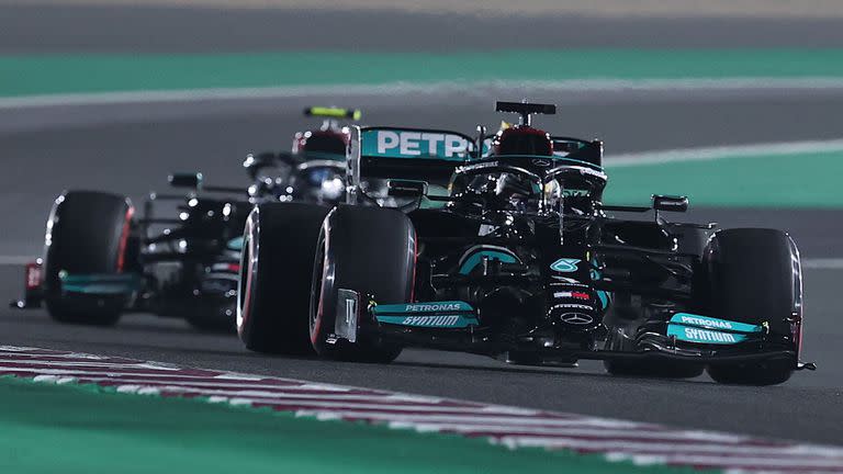 Mercedes' British driver Lewis Hamilton (foreground) and his teammate, Mercedes' Finnish driver Valtteri Bottas, drive during the qualifying session ahead of the Qatari Formula One Grand Prix at the Losail International Circuit, on the outskirts of the capital city of Doha, on November 20, 2021. (Photo by KARIM JAAFAR / AFP)