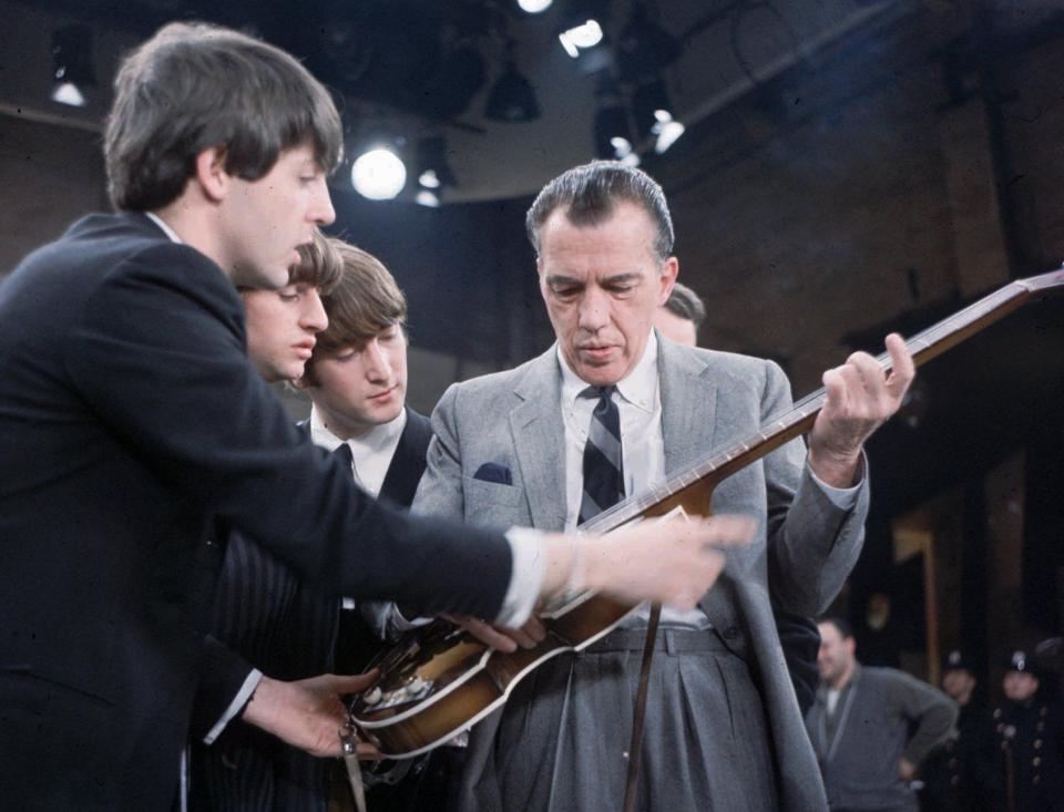The Beatles’ Paul McCartney , left, lets Ed Sullivan examine his violin-shaped Hofner bass in the Ed Sullivan Theater prior to the group’s appearance on Sullivan’s variety show on Feb. 9, 1964. From left are McCartney, Ringo Starr, John Lennon and Sullivan.
