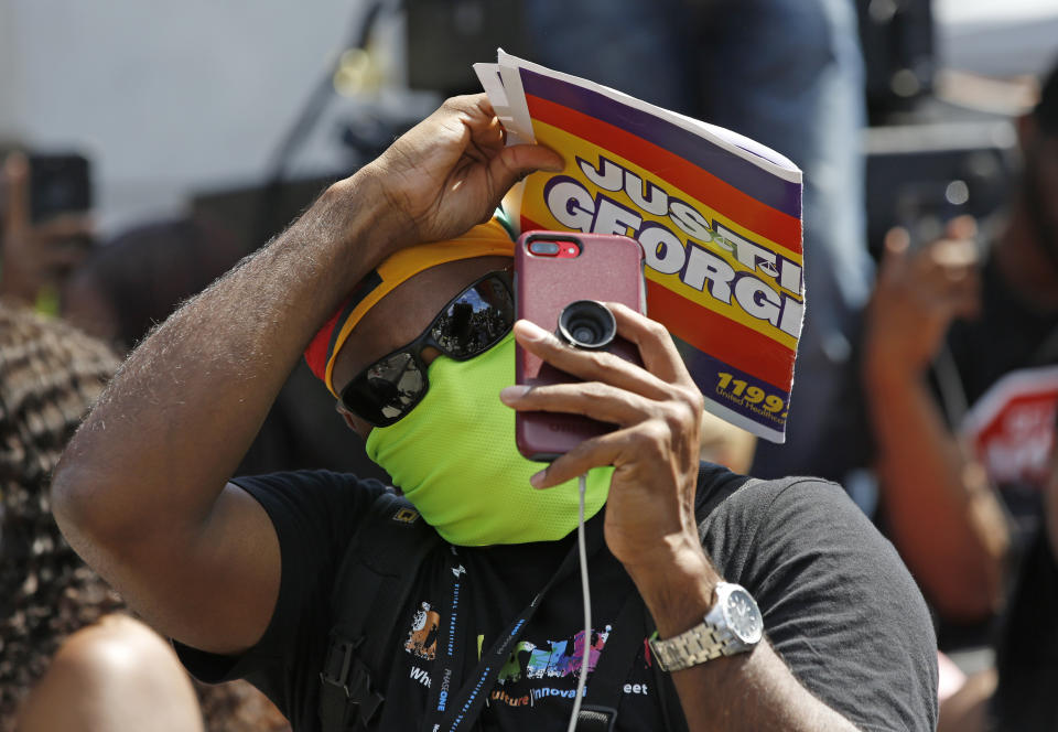 A person uses his cell phone to record during a Caribbean-led Black Lives Matter rally at Brooklyn's Grand Army Plaza, Sunday, June 14, 2020, in New York. (AP Photo/Kathy Willens)