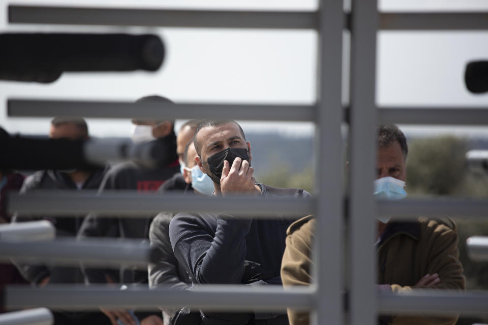 Palestinian workers wait behind a security gate for the Moderna coronavirus vaccine at the Hashmonim checkpoint between the West Bank and Israel, near the Israeli West Bank settlement of Nili, Monday, March 8, 2021. After delays, Israel started vaccinating Palestinians who work inside the country and its West Bank settlements on Monday, more than two months after launching an immunization blitz of its own population. (AP Photo/Maya Alleruzzo)