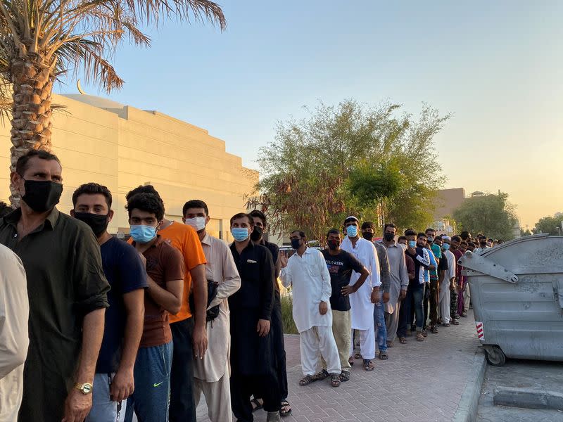 FILE PHOTO: Unemployed men queue for food handouts from concerned local residents after they lost incomes due to the coronavirus disease (COVID-19) pandemic in Dubai