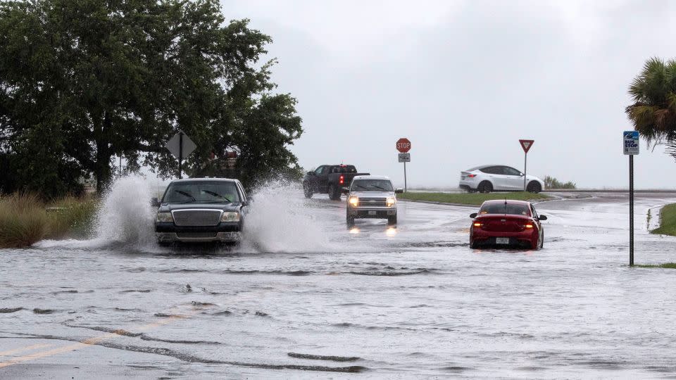 Vehicles drive through floodwaters in Pensacola, Florida, on Monday. - Tony Giberson/Pensacola News-Journal/USA Today Network