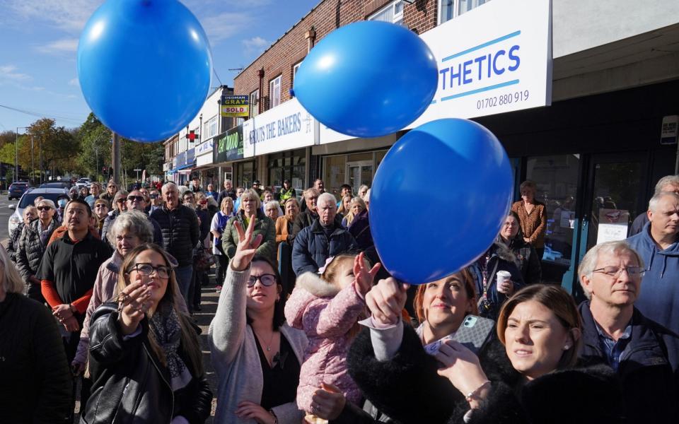 Shopkeepers and local residents release balloons as they gather to observe a two-minute silence in memory of MP Sir David Amess  - Stefan Rousseau/PA Wire