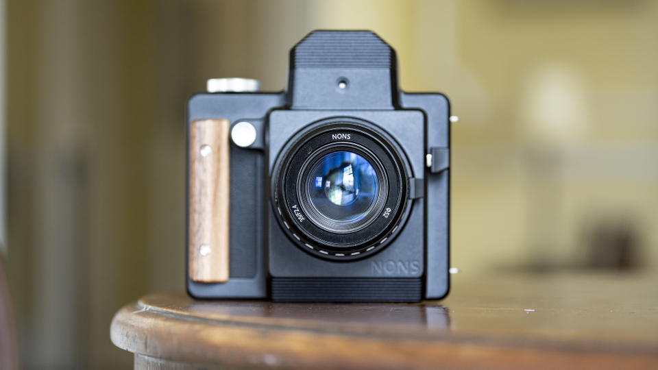 Nons SL660 instant camera on a mahogany table