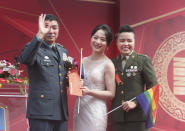 Lesbian couple Yi Wang, right, Yumi Meng and General Chen Pao-Yu pose for a photo during a military mass weddings ceremony in Taoyuan city, northern Taiwan, Friday, Oct. 30, 2020. Two lesbian couples tied the knot in a mass ceremony held by Taiwan's military on Friday in a historic step for the island. Taiwan is the only place in Asia to have legalized gay marriage, passing legislation in this regard in May 2019. (AP Photo/Chiang Ying-ying)