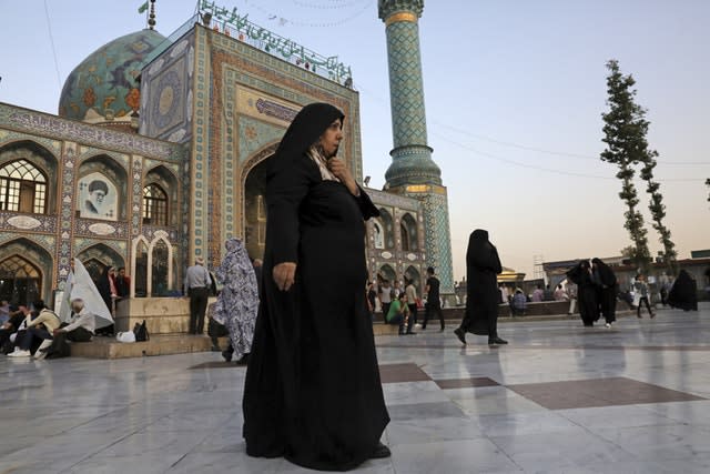 A head-to-toe veiled woman walks in the courtyard of the shrine of Saint Saleh in northern Tehran