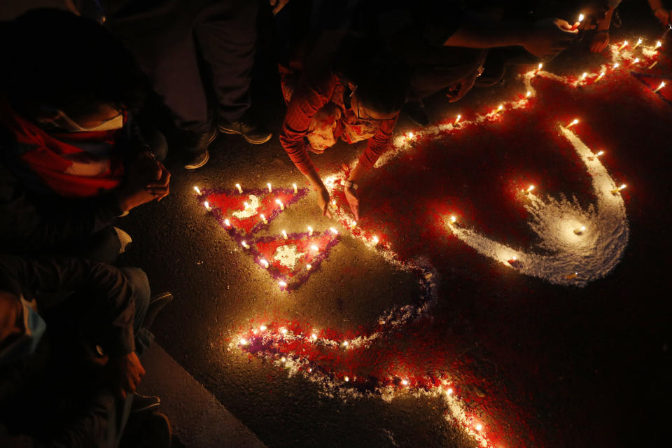 People light candles on an outline of the new map of Nepal drawn on a road as they celebrate the approval of the political map to include territory claimed by both India and Nepal, in Kathmandu, Nepal, Saturday, June 13, 2020. Nepal’s Parliament on Saturday overwhelmingly approved the constitutional amendment to change the nation’s political map. The voting follows the government's issuing of a new map last month that showed the disputed territory within its borders. (AP Photo/Niranjan Shrestha)