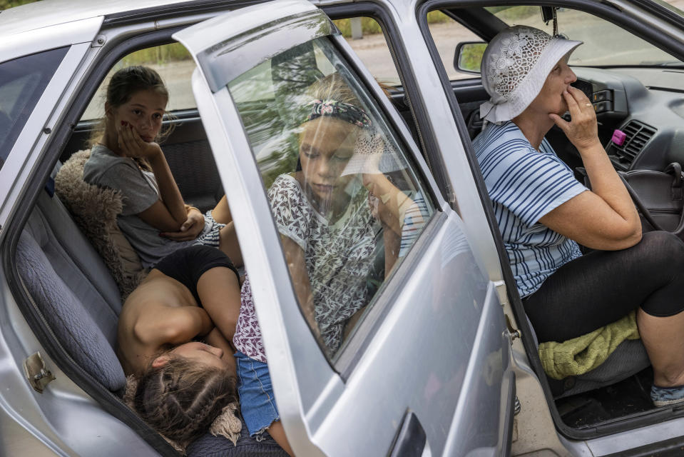 Mientras los combates provocan estragos alrededor de una planta nuclear en Zaporiyia, una familia ucraniana se une a un convoy de civiles que huyen de la zona el 14 de agosto de 2022. (David Guttenfelder/The New York Times)