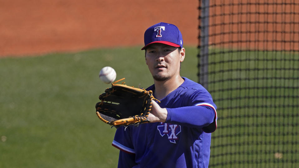 Texas Rangers pitcher Kohei Arihara, from Japan, catches a ball during spring training baseball practice Wednesday, Feb. 24, 2021, in Surprise, Ariz. (AP Photo/Charlie Riedel)