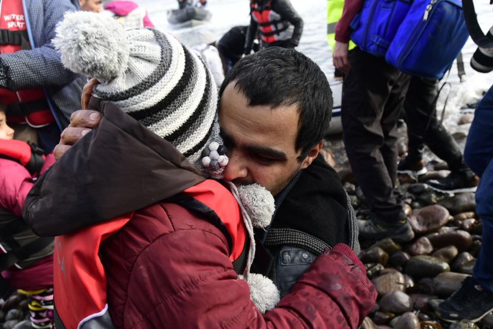 A man hugs a child upon their arrival at the village of Skala Sikaminias, on the Greek island of Lesbos, after crossing the Aegean sea from Turkey, on Friday, Feb. 28, 2020. An air strike by Syrian government forces killed scores of Turkish soldiers in northeast Syria, a Turkish official said Friday, marking the largest death toll for Turkey in a single day since it first intervened in Syria in 2016. (AP Photo/Micheal Varaklas)