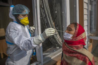 A health worker takes a nasal swab sample of a Kashmiri to test for COVID-19 in Srinagar, Indian-controlled Kashmir, Wednesday, Jan. 20, 2021. The global death toll from COVID-19 topped 2 million last week as vaccines developed at breakneck speed are being rolled out around the world in an all-out campaign to vanquish the threat.(AP Photo/Dar Yasin)