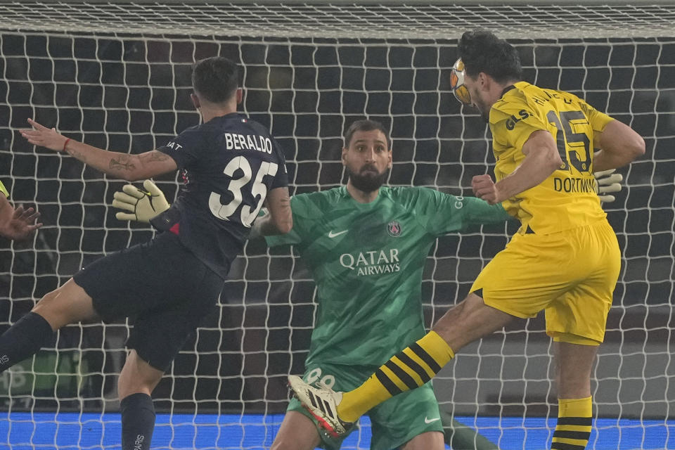 Dortmund's Mats Hummels, right, scores his side's opening goal during the Champions League semifinal second leg soccer match between Paris Saint-Germain and Borussia Dortmund at the Parc des Princes stadium in Paris, France, Tuesday, May 7, 2024. (AP Photo/Frank Augstein)