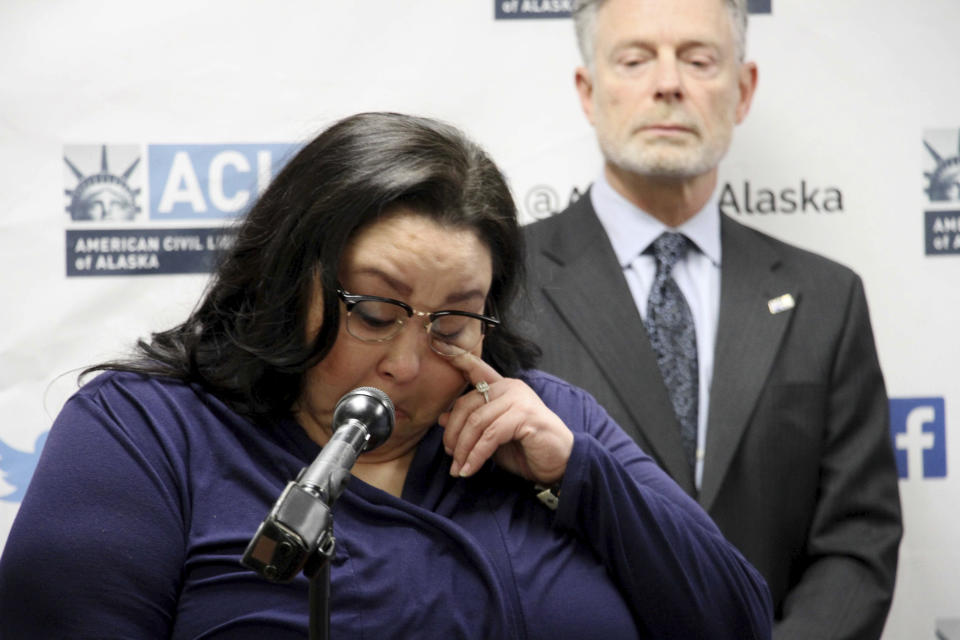 Clarice Hardy wipes a tear away from her eye during a news conference Thursday, Feb. 20, 2020, in Anchorage, Alaska. The American Civil Liberties Union of Alaska filed a lawsuit Thursday on Hardy's behalf against the City of Nome, Alaska, and two former officers for failing to investigate the sexual assault report filed by Hardy, a former police dispatcher. On the right is Stephen Koteff, the ACLU's legal director in Alaska. (AP Photo/Mark Thiessen)