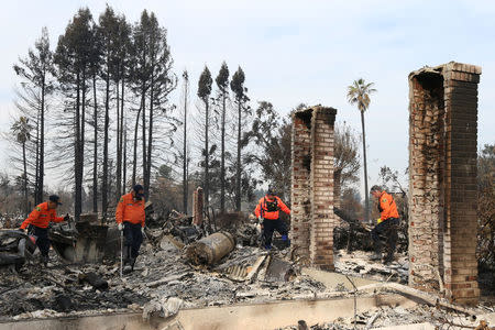 Search and rescue personnel inspect the aftermath of the Tubbs Fire in the Coffey Park neighborhood of Santa Rosa, California U.S., October 17, 2017. REUTERS/Loren Elliott