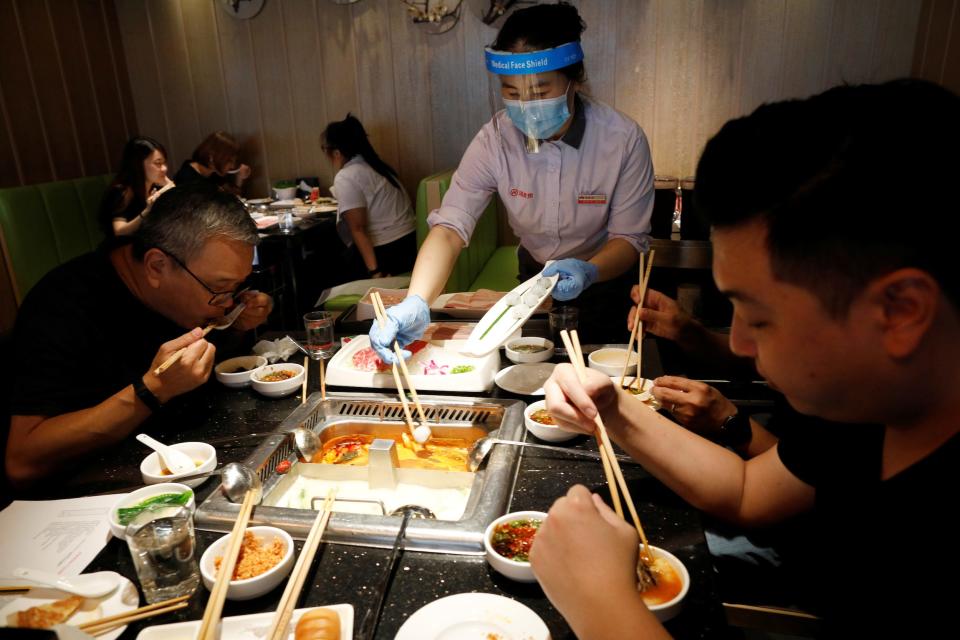 People eat at a busy steamboat restaurant in Singapore as the city state reopens the economy amid the coronavirus disease (COVID-19) outbreak, June 19, 2020. REUTERS/Edgar Su