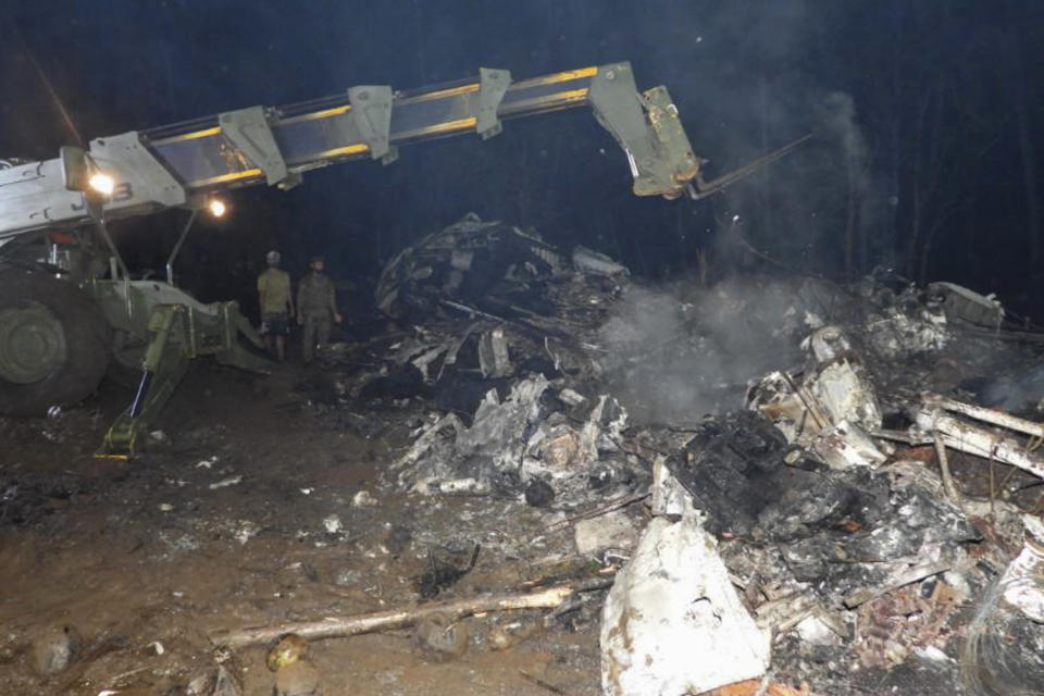 In this photo released by the Joint Task Force - Sulu, military soldiers work near the remains of a Philippine military C-130 plane that crashed in Patikul town, Sulu province, southern Philippines on Sunday July 4, 2021. The Lockheed C-130 Hercules, which was carrying 96 mostly combat troops, overshot the runway while landing Sunday at the Jolo airport. (Joint Task Force-Sulu via AP)