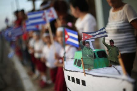 A miniature replica of the Granma yacht carries figures of Fidel and Raul Castro, as people await the arrival of the caravan carrying the ashes of Fidel Castro in Guaimaro, Cuba, December 2, 2016. REUTERS/Edgard Garrido/Files