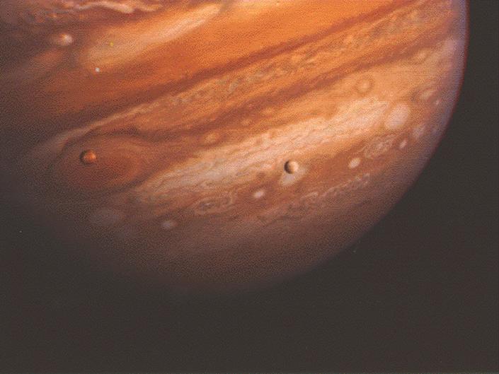 Jupiter and two of its moons is shown in a picture taken by Voyager.