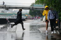 People running in the rain in London, Wednesday Aug. 17, 2022.. After weeks of sweltering weather, which has caused drought and left land parched, the Met Office's yellow thunderstorm warning forecasts torrential rain and thunderstorms that could hit parts England and Wales. (Victoria Jones/PA via AP)