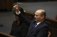 Israel's new prime minister Naftali Bennett raises his hand during a Knesset session in Jerusalem Sunday, June 13, 2021. Israel's parliament has voted in favor of a new coalition government, formally ending Prime Minister Benjamin Netanyahu's historic 12-year rule. Naftali Bennett, a former ally of Netanyahu became the new prime minister (AP Photo/Ariel Schalit)