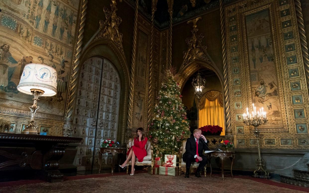 President Donald Trump and first lady Melania Trump speak on the phone with children as they track Santa Claus' movements with the North American Aerospace Defense Command (NORAD) Santa Tracker on Christmas Eve at the president's Mar-a-Lago estate in Palm Beach - AP